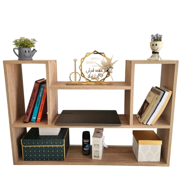 Vue de face d'une étagère murale en bois beige à plusieurs compartiments, contenant des livres, des boîtes décoratives et un ordinateur portable, sur fond transparent.