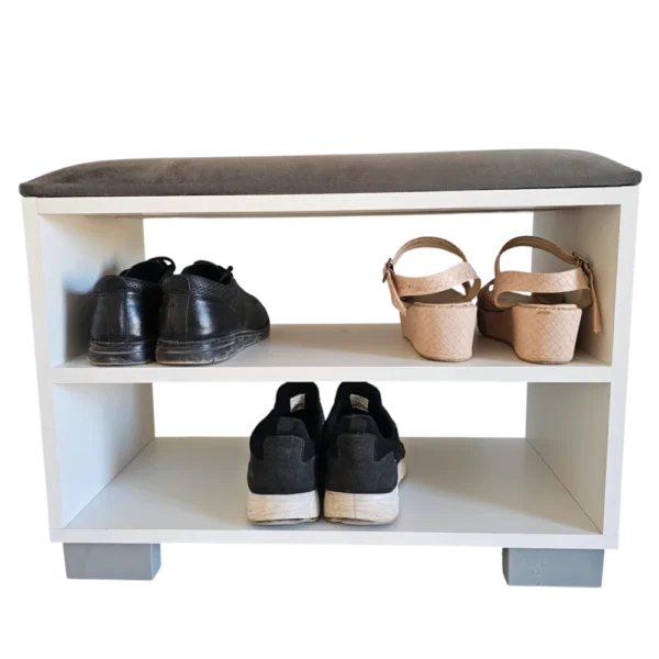 Vue de face d'un banc à chaussures blanc à deux niveaux avec un coussin d'assise gris foncé. Trois paires de chaussures sont rangées sur les étagères pour montrer la capacité.