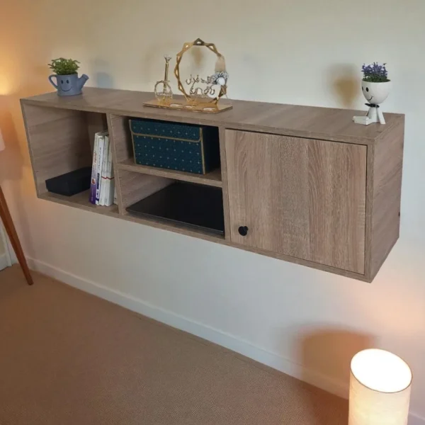 Vue en angle d'une étagère murale flottante en bois, montrant les compartiments ouverts et fermés avec des décorations.