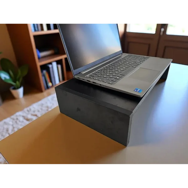 Rehausseur d'écran noir au design minimaliste, posé sur un bureau pour surélever un ordinateur portable à hauteur des yeux.