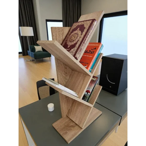 Étagère en zigzag couleur bois posée sur un bureau gris dans un salon ou bureau moderne.