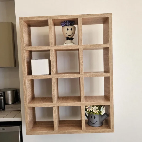 Étagère murale à casiers carrés en bois, fixée sur un mur blanc pour un rangement mural optimisé.