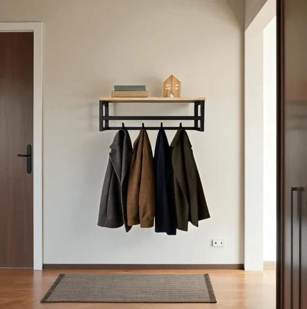 Porte-manteau mural design utilisé comme rangement dans une entrée de maison, avec des manteaux accrochés.