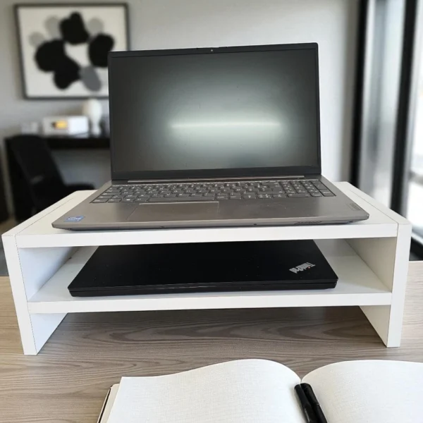 Support d'écran ergonomique blanc posé sur un bureau en bois pour améliorer la posture de travail.