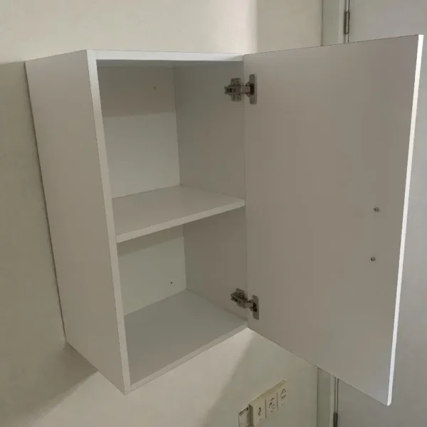 Petite armoire murale blanche vide avec porte ouverte montrant la tablette intérieure de rangement.