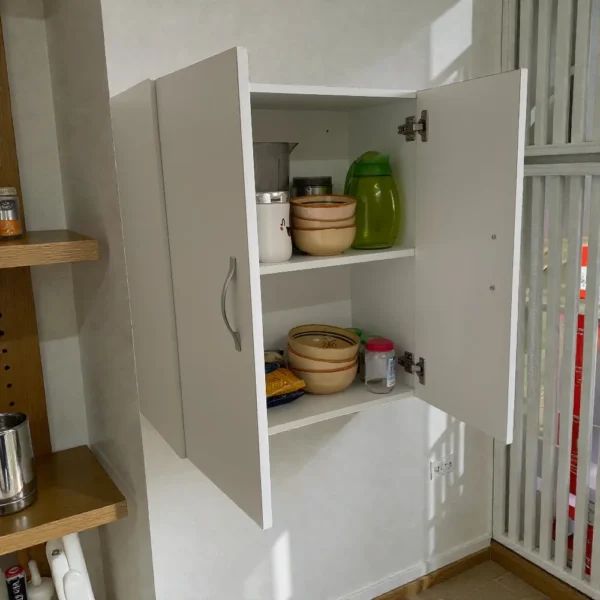 Meuble mural blanc suspendu ouvert, présenté comme une solution polyvalente pour la salle de bain ou les WC. Rangement compact avec tablette intérieure pour serviettes, cosmétiques ou petit kit de secours.