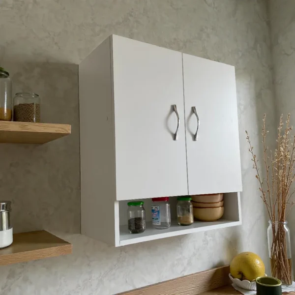 Meuble haut blanc utilisé comme rangement pour épices et bols dans une cuisine, à côté d'étagères en bois.