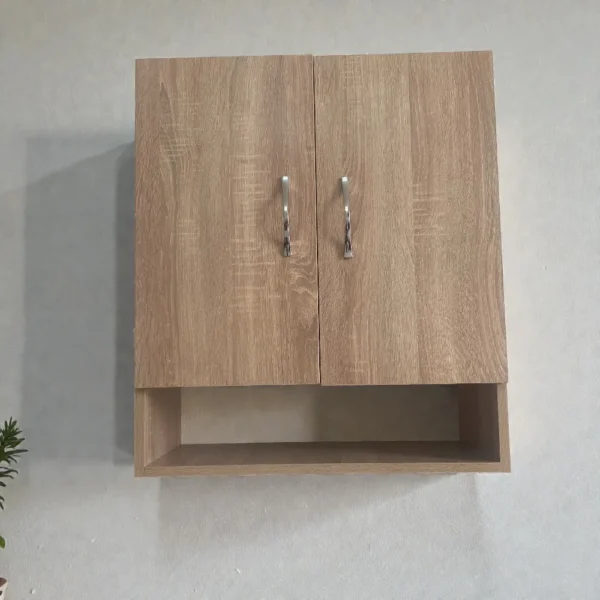 Élément haut de cuisine en mélaminé imitation bois chêne clair avec deux portes et poignées chromées sur un mur blanc.