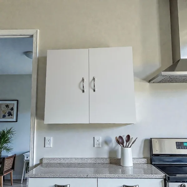 Meuble mural blanc 2 portes de 80 cm de large, fixé au mur pour un gain de place optimal.
