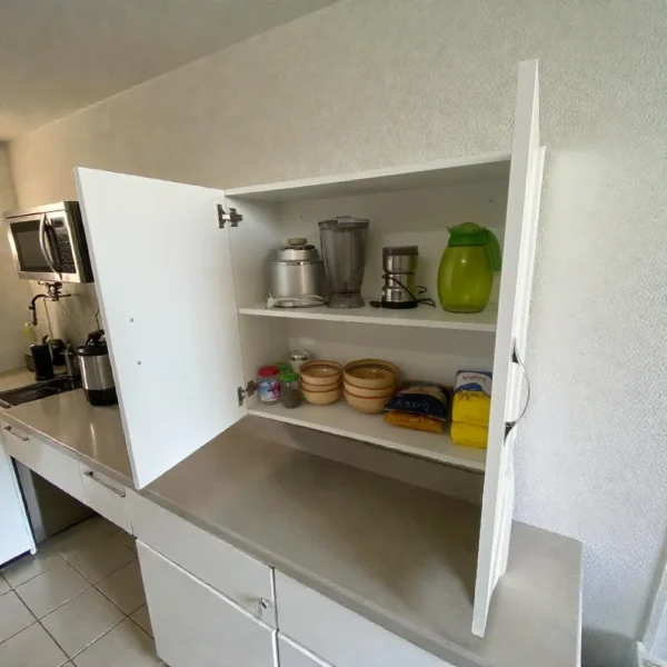 Meuble d'appoint mural blanc ouvert montrant un grand espace de stockage pour cosmétiques ou produits de secours.