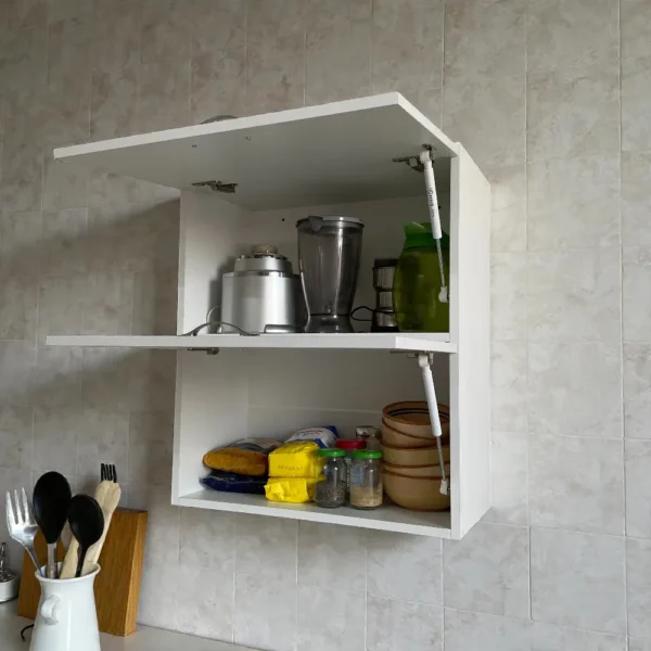 Élément haut de cuisine blanc ouvert montrant un rangement organisé avec un mixeur, une carafe et des bols.