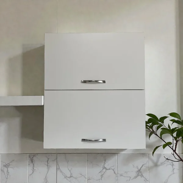 Vue de face d'un placard de cuisine suspendu blanc avec deux poignées chromées sur un carrelage mural.